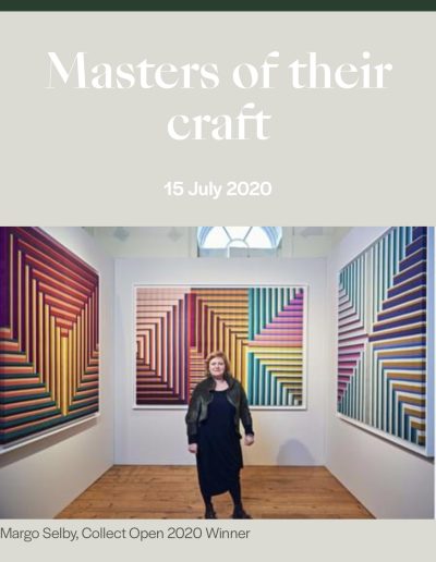 Front cover of Atomos magazine showing an artist in front of her colourful wall mounted textile artwork