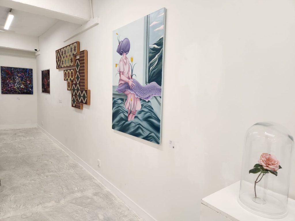 Installation view of Defying Boundaries: Female Vision at Karin Weber Gallery, Hong Kong, showing Winter Camellia displayed beneath a glass dome alongside works by other gallery artists.